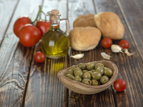 olive oil and olives on a wooden table. 