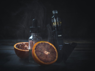 black vaporizer in the smoke with sliced orange