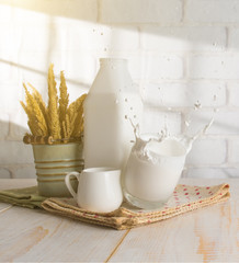 Splash of milk from the glass on wood with shadows from a window frame