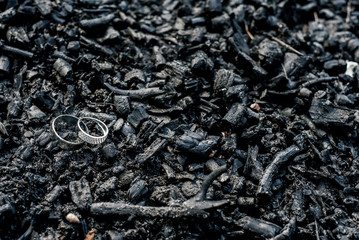 Golden wedding rings on black charcoa, selective focus, tilt-shift, free space