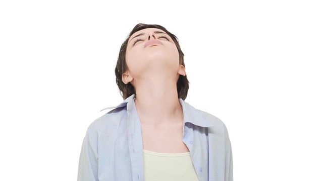 Young tired Caucasian female with beautiful short hair sighing heavily over white background in slowmotion and massaging neck