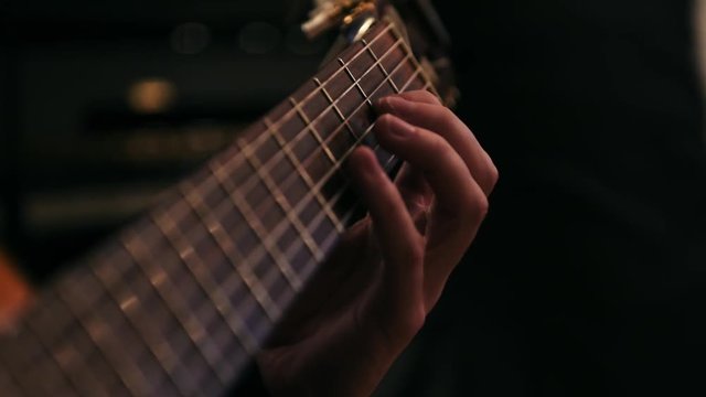 Tr&egrave;s gros plan d'un homme jouant &agrave; la guitare acoustique