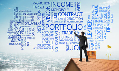 Young businessman standing on house roof and writing leadership skill concept. Mixed media