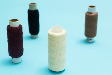 Background of old rolls of thread on a blue table.