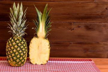 Ripe anans on a wooden table and background texture with free space for writing