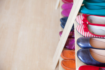 Rows of colorful women's shoes (ballet shoes) in the wardrobe. Selective focus