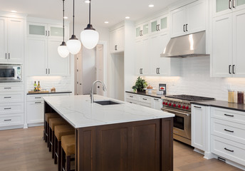 Kitchen Interior with Island, Sink, Cabinets, and Hardwood Floors in New Luxury Home