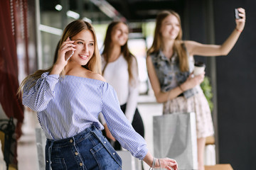 happy young woman talking on the phone in shopping mall