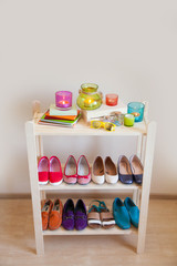 Rows of colorful women's shoes (ballet shoes) in the wardrobe. Selective focus