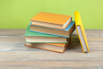 Stack of colorful books on wooden desk. Copy space for text.. Back to school. Education background.