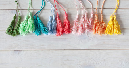 Tassels made of thread. Colored yarn in coils. Needle and accessories for needlework.