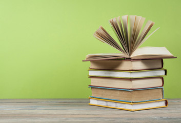Open book, hardback books on wooden table. Education background. Back to school. Copy space for text.