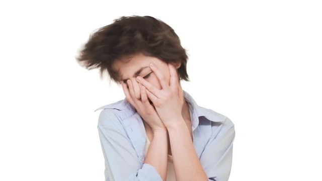 Beautiful young Caucasian girl shaking hear head actively in despair. Footage on white background in slowmotion