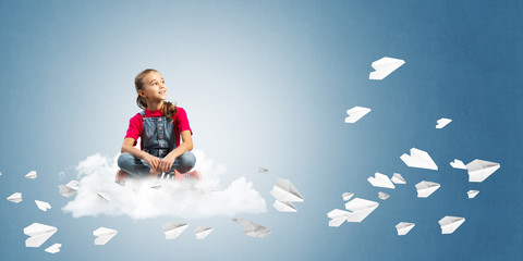 Concept of careless happy childhood with girl dreaming about something