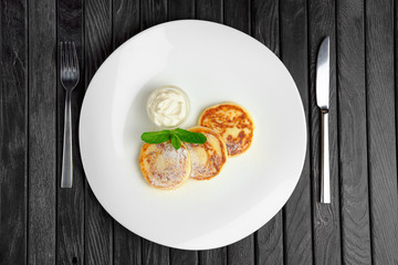 Top view of cottage cheese fritters with sugar powder