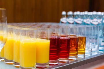 food background. many glasses with natural juice with orange on buffet table