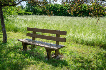 Fototapeta na wymiar French countryside. A bench at the edge of the road somewhere in Lorraine.