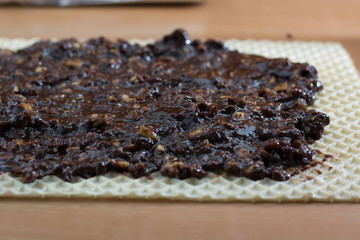 Coating chocolate topping with wallnuts on cake crust