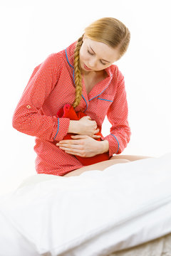 Woman feeling stomach cramps lying on bed