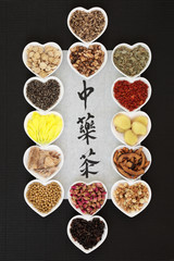 Traditional chinese herb tea selection with calligraphy on rice paper on black ridged paper background. Teas also used in natural alternative medicine. Translation reads as chinese herb tea.