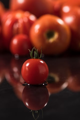  Tomatoes on black background ,water drops , mirror