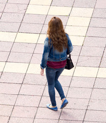 The girl is walking along paving stones