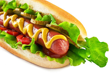 Classic Hot Dog with big sausage, fresh salad, tomatoes and pickled cucumbers isolated on white background