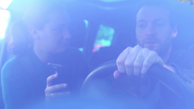 Couple using smartphone in car