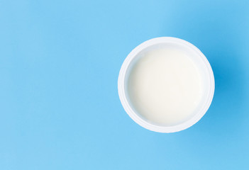 Obraz na płótnie Canvas Closeup top view greek yogurt in white cup with blue background