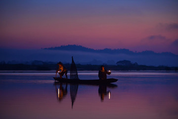 Silhouette fisherman are moveing to fishing on before sunrise,during sunrise,Thailand