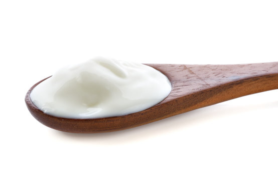 yogurt on wooden spoon isolated on white.