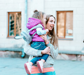 Mother holds a small daughter in her arms