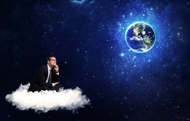 Obraz na płótnie Canvas Man sitting on cloud looking at planet earth