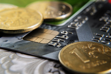 Coins lie on the credit card close up.