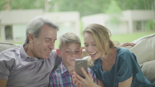 Family posing for selfie on sofa