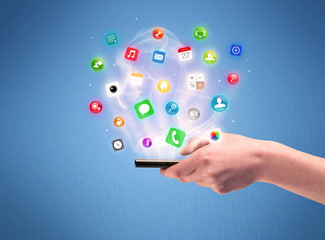 Hand holding tablet phone with app icons