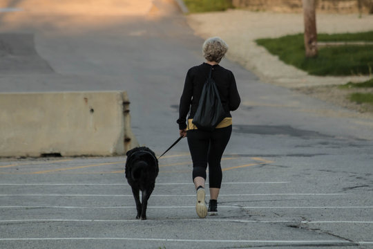 Woman walking black dog