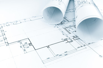 floor plan drawing with rolls of architectural blueprints