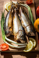 Smoked mackerel fish on wooden hardboard on wooden table