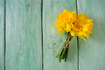 yellow daffodils on turquoise wooden surface