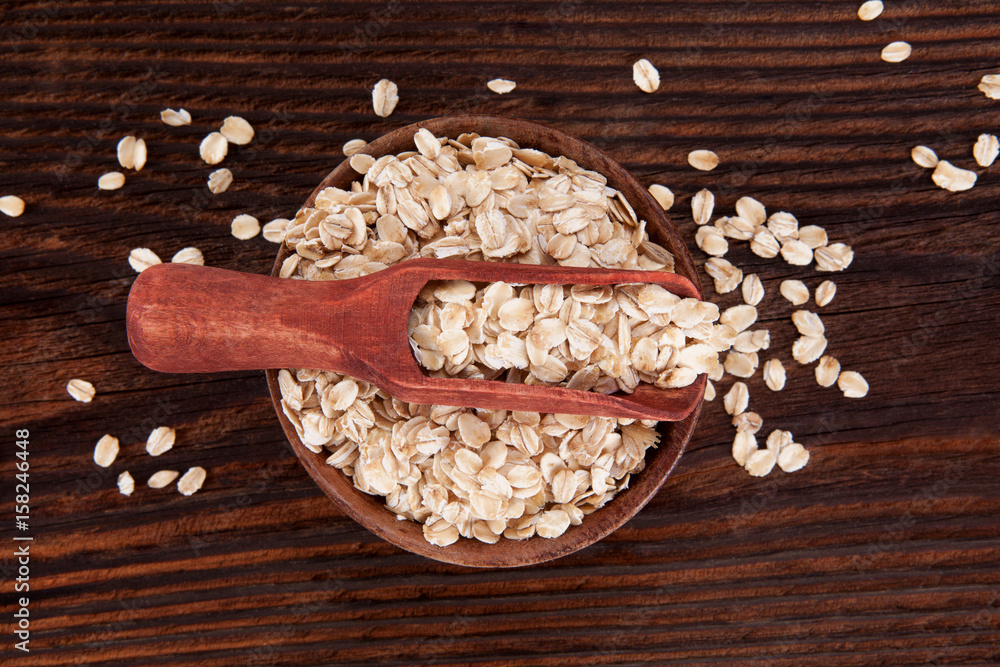 Wall mural oatmeal flakes on wooden table.