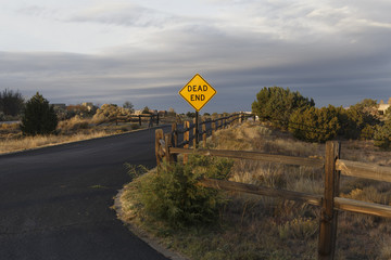 a dead end sign lit by the rising sun