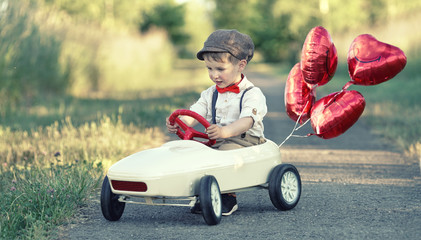 im Tretauto mit Ballons