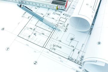 drawing and measurement tools, architectural plan and rolls of blueprints