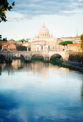 Fototapeta na wymiar St. Peter's cathedral over bridge and river Tiber water in Rome, Italy, retro toned