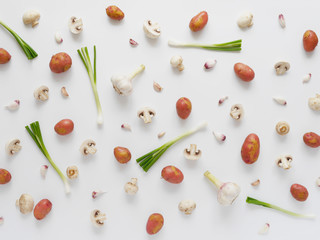 Vegetables  on a white background. Pattern of vegetables. Food background. Collage of food. Top view. Young potatoes, mushrooms, champignons and green onions on a white background.