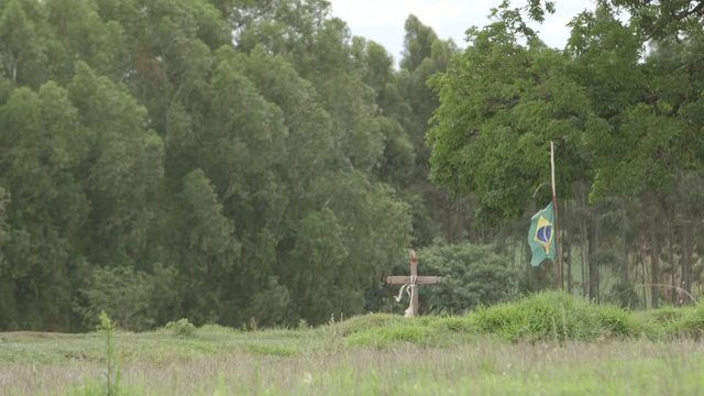 grave in the middle of the forest with Brazil flag waving 