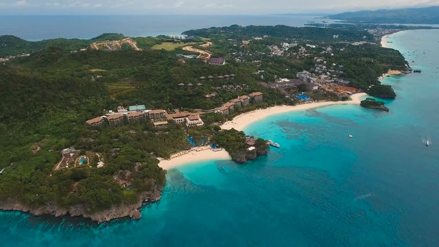 Aerial view of beautiful tropical island with white sand beach, hotels and tourists. Tropical lagoon with turquoise water and white sand. Beautiful sky, sea, beach, resort. Beautiful tropical beach of