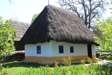 Fototapeta na wymiar House with straw roof in Dimitrie Gusti National Village Museum in Bucharest, Romania