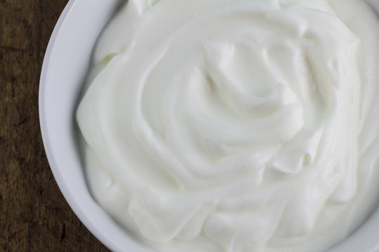 Bowl of Greek swirled natural yoghurt close up